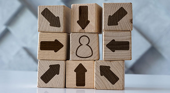 A stack of wooden blocks, some with arrows pointing on them - Estate-Mate