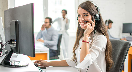 woman wearing a headset, working in an office environment - Estate Mate