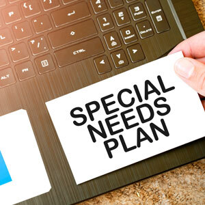 Law firm guidance on special needs planning, card held over laptop keyboard